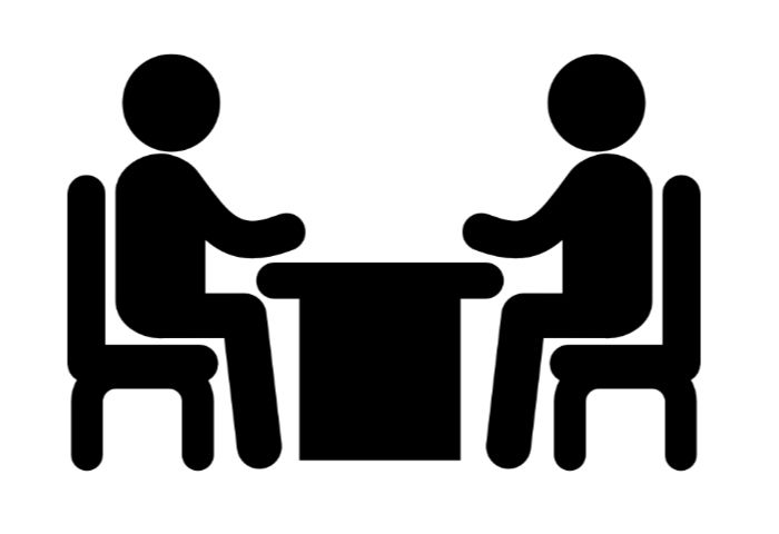 Two people sitting at a table, outlined